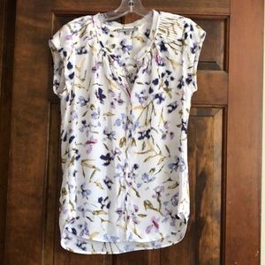 Short sleeved cream, flowered blouse.